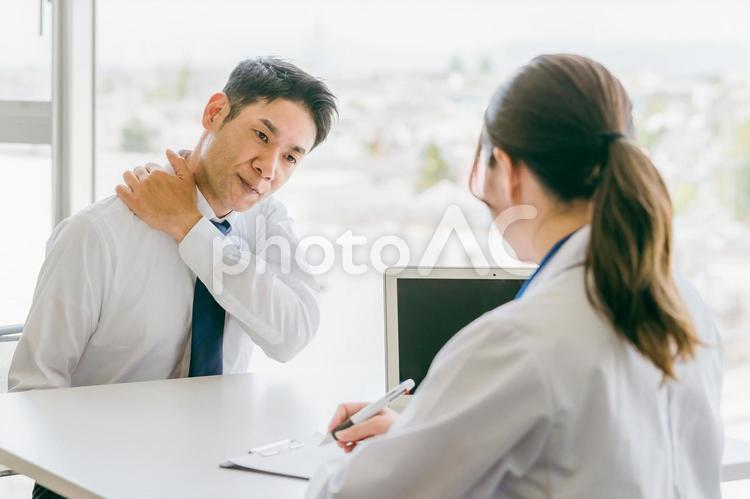 肩の痛み・肩こりを医師に相談する中年男性 肩こり,肩,四十肩の写真素材