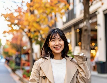 秋の街を歩く笑顔の女性 秋の街を歩く笑顔の女性の写真