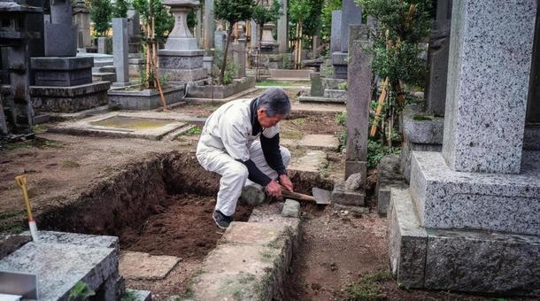 墓地で石材作業をする職人・墓の修繕・霊園 墓地で石材作業をする職人・墓の修繕・霊園の写真