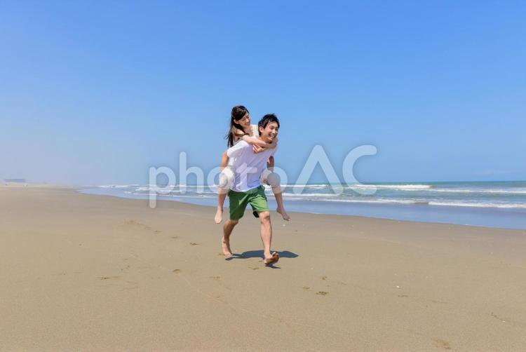 砂浜をおんぶして歩くカップル3 カップル,日本人,夏の写真素材
