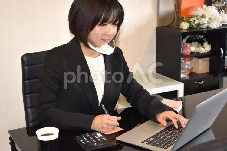 マウスシールドを付けてタイピング&メモを取る女性 ビジネス,女性,仕事の写真素材