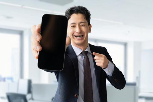 スマホの画面を見せる男性ビジネスマン 男性,スマホ,スマートフォンの写真素材