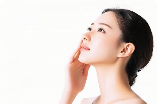 頬に手を添える若い女性の横顔 頬に手を添える若い女性の横顔の写真