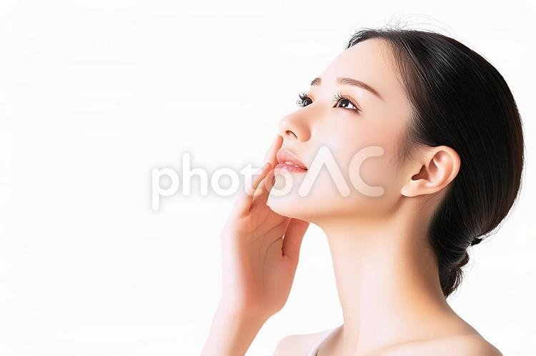 頬に手を添える若い女性の横顔 美容,スキンケア,横顔の写真素材