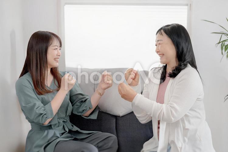 ファイティングポーズで遊ぶ女性二人 女性,笑顔,室内の写真素材
