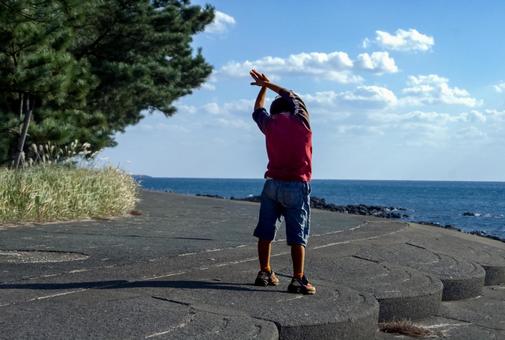 ＜素材＞朝の海でストレッチをする男の子 子供,海,空の写真素材