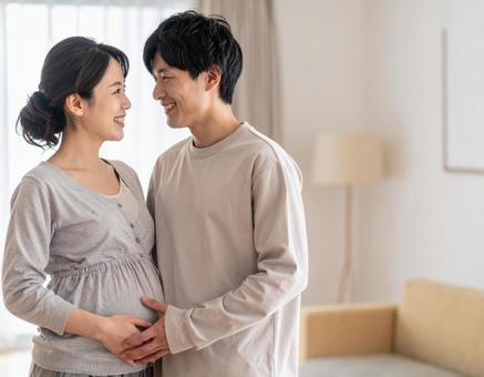 妊娠中の妻と幸せそうに寄り添う夫婦 妊娠中の妻と幸せそうに寄り添う夫婦の写真