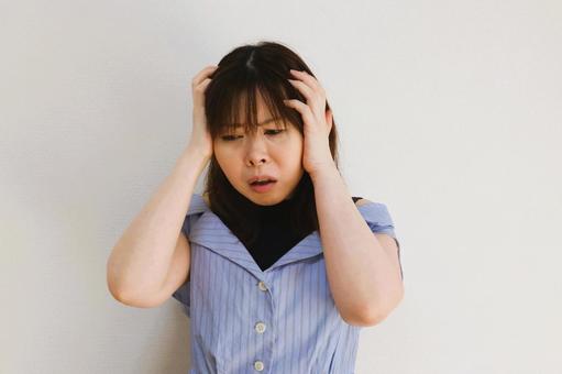 頭を抱える女性 頭を抱える女性の写真