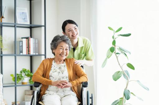 車椅子のシニアの女性と若い介護福祉士 車椅子のシニアの女性と若い介護福祉士 介護,シニア,車椅子の写真素材