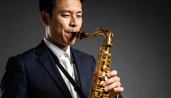 バリトンサックスを演奏する男性 バリトンサックスを演奏する男性の写真