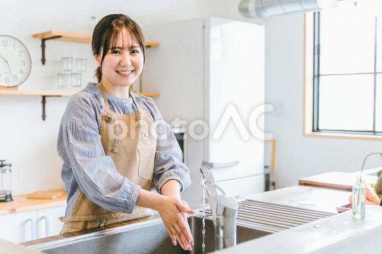 調理前に手を洗うエプロンをつけた女性 女性,洗う,手の写真素材