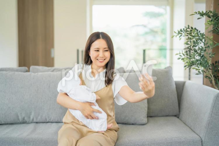 赤ちゃんと写真を撮る女性 赤ちゃん,ママ,子育ての写真素材