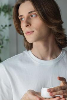 クリームのジャーを持って横を見ている男性 男性,外国人,欧米人の写真素材