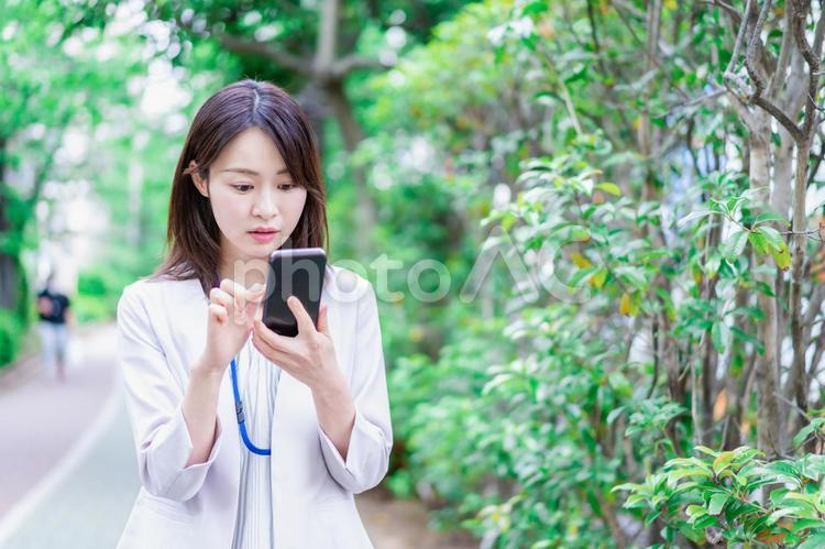 地図アプリを使う若いビジネスウーマン 現在地,見渡す,見るの写真素材
