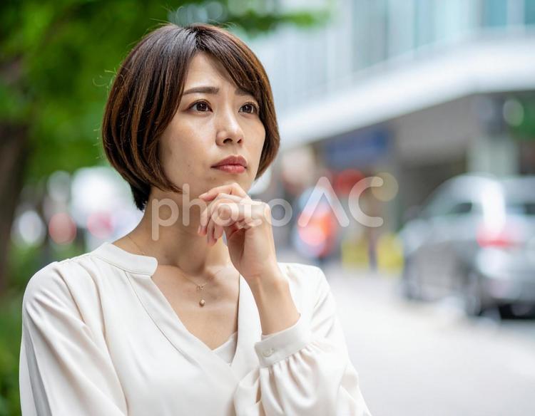 不安そうな表情で考え込む若い女性 考える,不安,表情の写真素材