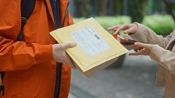 街なかで配達物を渡す配達員 配達,デリバリー,配送の写真素材