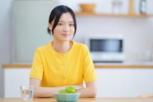 シャインマスカットとカメラ目線の女性の写真