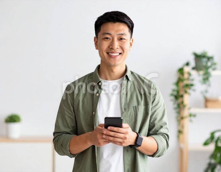 室内でスマートフォンを持ち笑顔の男性 男性,笑顔,人物の写真素材