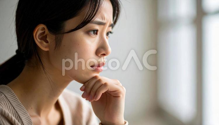 困った顔で手を顎に当てる若い女性 困惑,頭痛,病気の写真素材