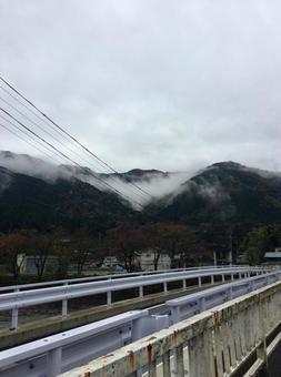 霧が立ち込める山と橋の上の電線 霧が立ち込める山と橋の上の電線の写真