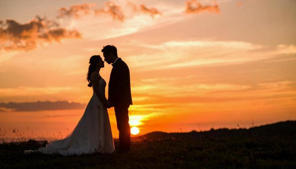 夕日の草原の中の花嫁と花婿 ウエディング 夕日の草原の中の花嫁と花婿 ウエディングの写真