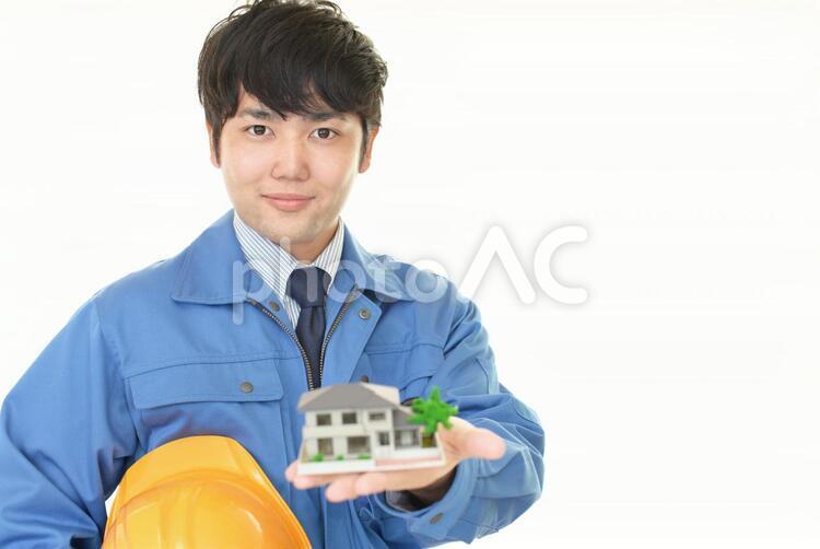 住宅模型を持つ笑顔の労働者 男性,労働者,作業員の写真素材