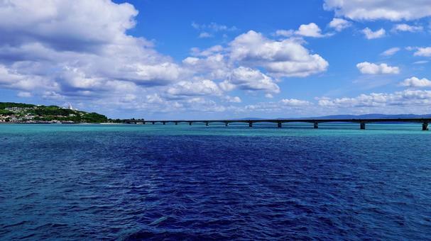 海から見える古宇利大橋と空 海から見える古宇利大橋と空 古宇利大橋,古宇利島,海の写真素材