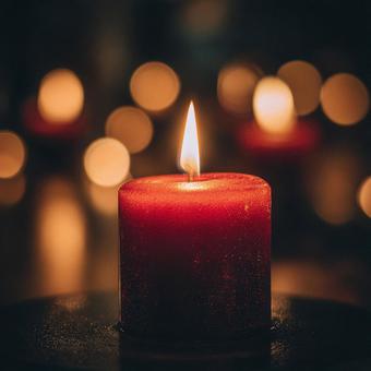 温かい光を放つ赤いロウソクの写真