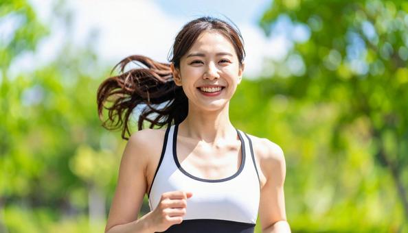 笑顔でジョギングする若い女性 笑顔でジョギングする若い女性の写真