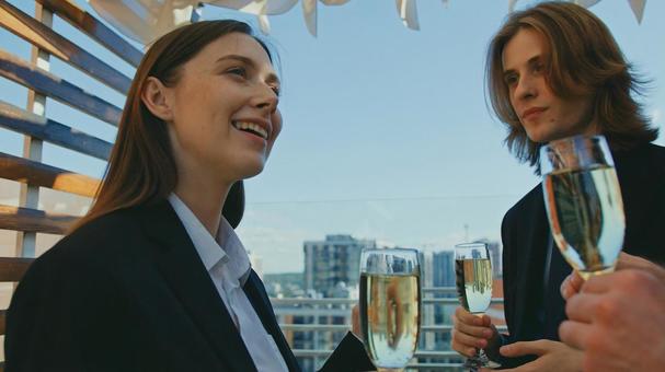 シャンパンを持ち嬉しそうな女性を見つめる男性 男女,外国人,シャンパングラスの写真素材