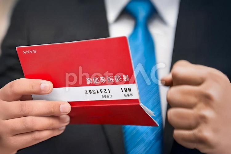 預金通帳を見る男性 通帳,預金通帳,初任給の写真素材