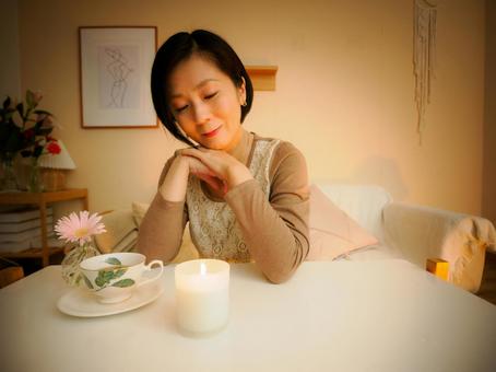 36:キャンドルを眺めてお茶を楽しむ女性 36:キャンドルを眺めてお茶を楽しむ女性 キャンドル,お茶,リラックスの写真素材