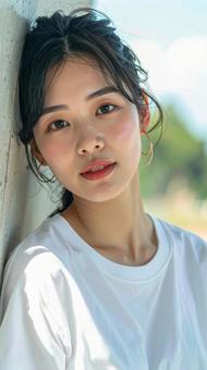 白いTシャツの女性が壁際でポーズをとる 白いTシャツの女性が壁際でポーズをとるの写真