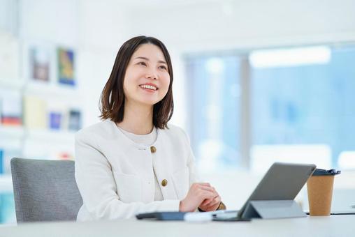 仕事中に同僚と会話する女性 仕事中に同僚と会話する女性 ビジネス,女性,会話の写真素材