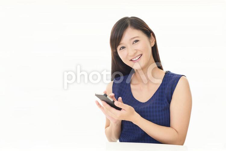 スマートフォンを持つ笑顔の女性 女性,スマートフォン,女の写真素材