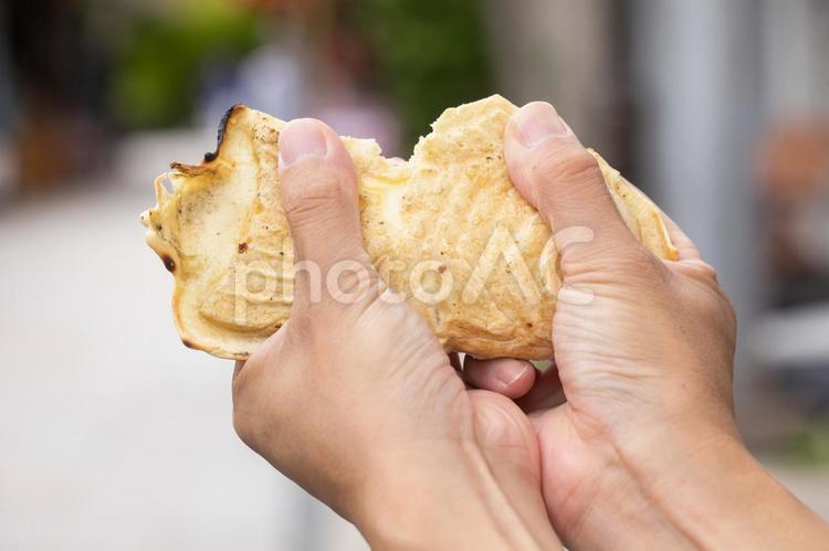 たい焼き手にとる男性　Japan たいやき,手元,指先の写真素材