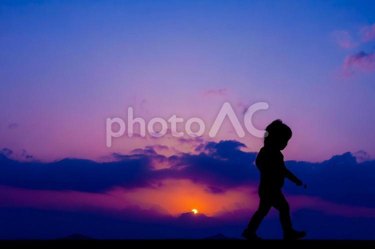 マジックアワーを歩く子供のシルエット 朝焼け,夕暮れ,夕空の写真素材