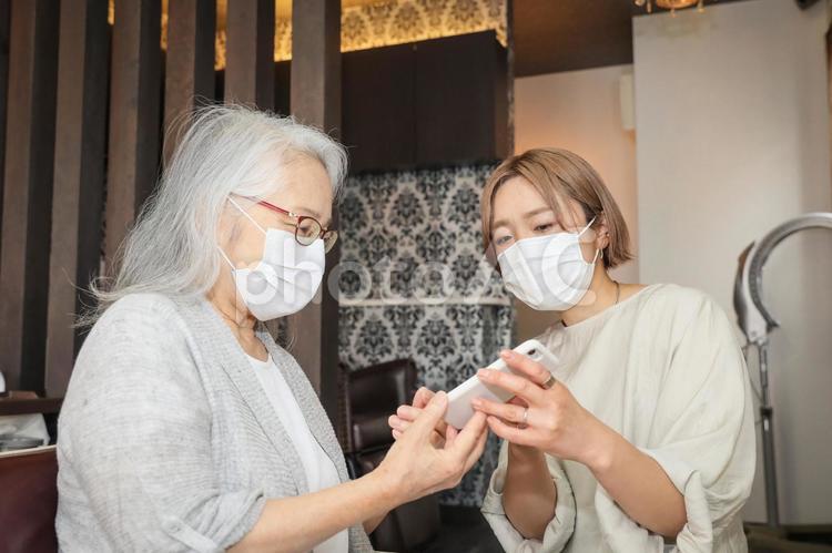 コロナ禍の美容室（カウンセリング・スマホ） 美容室,アプリ,高齢者の写真素材