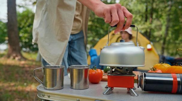 ケトルを持ち上げる手とバーナー ケトル,マグカップ,お湯の写真素材