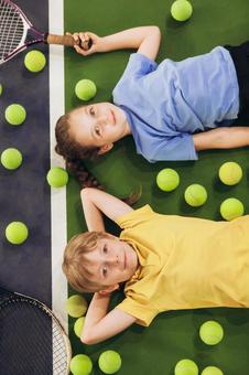 テニスコートに寝転ぶ子供たち 男女,子供,外国人の写真素材