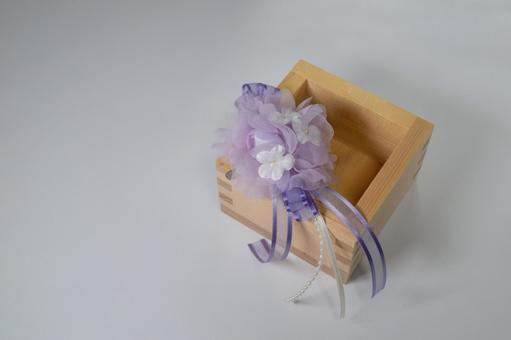 紫色のコサージュが添えられた木製の枡 枡,コサージュ,花の写真素材