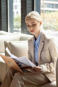 オフィスのソファで資料を読むビジネスウーマン ビジネスウーマン,ビジネス,女性の写真素材
