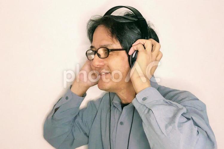 音楽を聴いて笑みを浮かべる男性 笑み,おもしろい,楽しいの写真素材