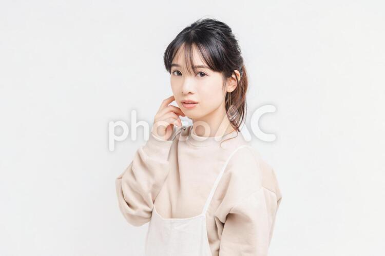 白い背景の前に立ってポーズをとる若い女性 女性,白背景,立つの写真素材