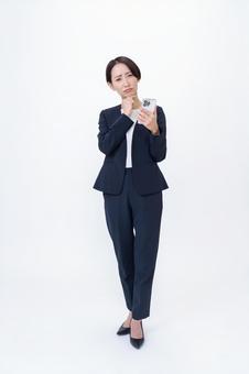 スマホを持ち考える女性 スマホを持ち考える女性 会社員,営業,キャリアの写真素材
