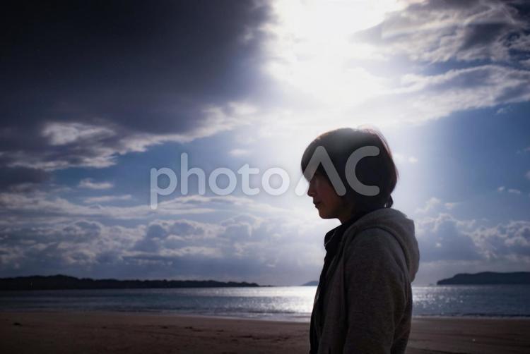 ＜素材＞夜明けの海を孤独に散策する女性 女性,人物,悩むの写真素材