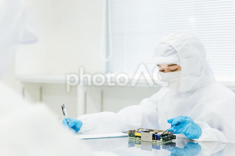 クリーンルームで精密機器を扱う女性 工場,製造業,精密機器の写真素材