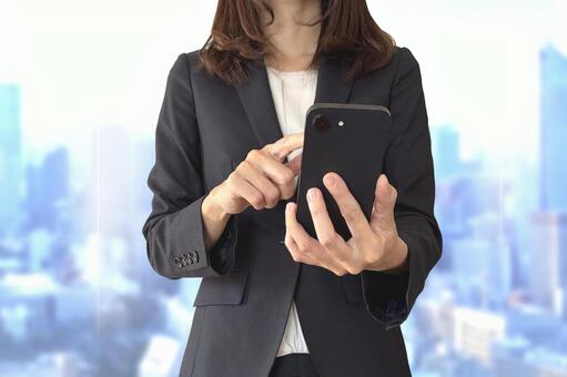 都会でスマホを使うビジネスウーマン スマホ,ビジネスウーマン,女性の写真素材