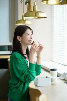 カフェでサンドイッチを食べる日本人女性 カフェでサンドイッチを食べる日本人女性 カフェ,女性,ランチの写真素材