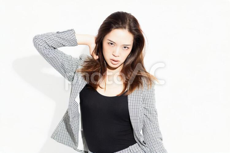 白い背景の前に立ってポーズをとるビジネスウーマン 女性,白背景,立つの写真素材